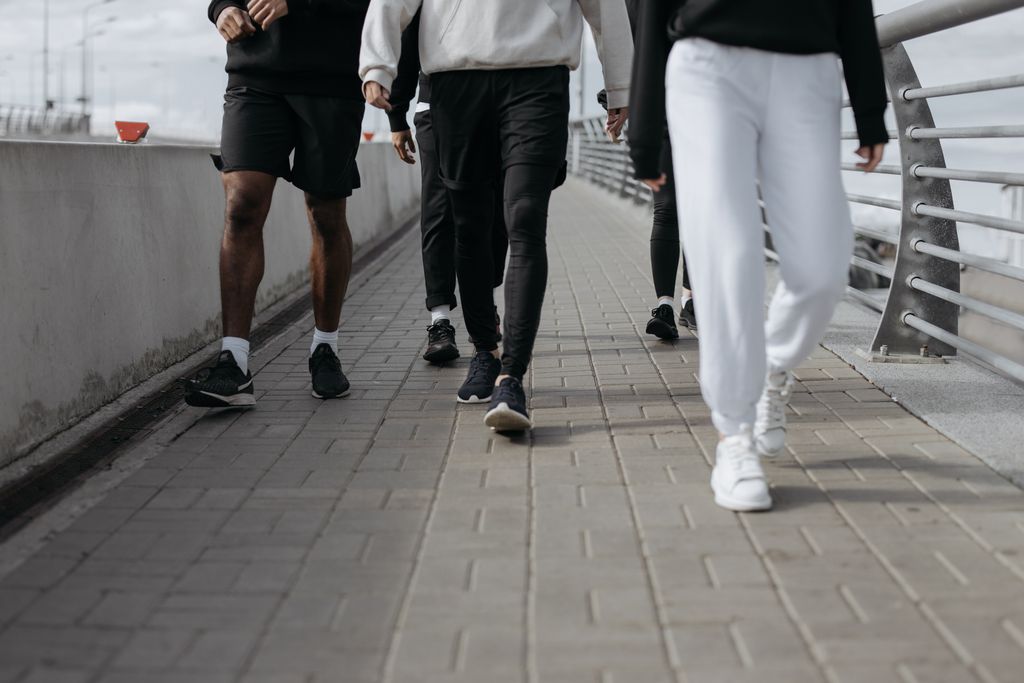 Casual group walk on a city sidewalk, showcasing modern fashion and footwear.